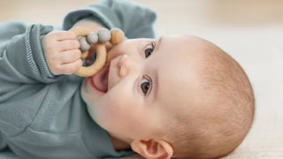 Baby greift Holzring — sensorisches Spielzeug für Babys
