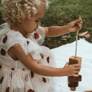Mädchen fädelt KAWI Senso Holzspielzeug – Fädelspiel aus Holz für Babys und Kleinkinder ab 10 Monaten