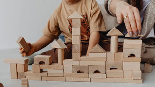 Kind spielt kreativ mit Holzspielzeug — offenes Spiel ohne Vorgaben
